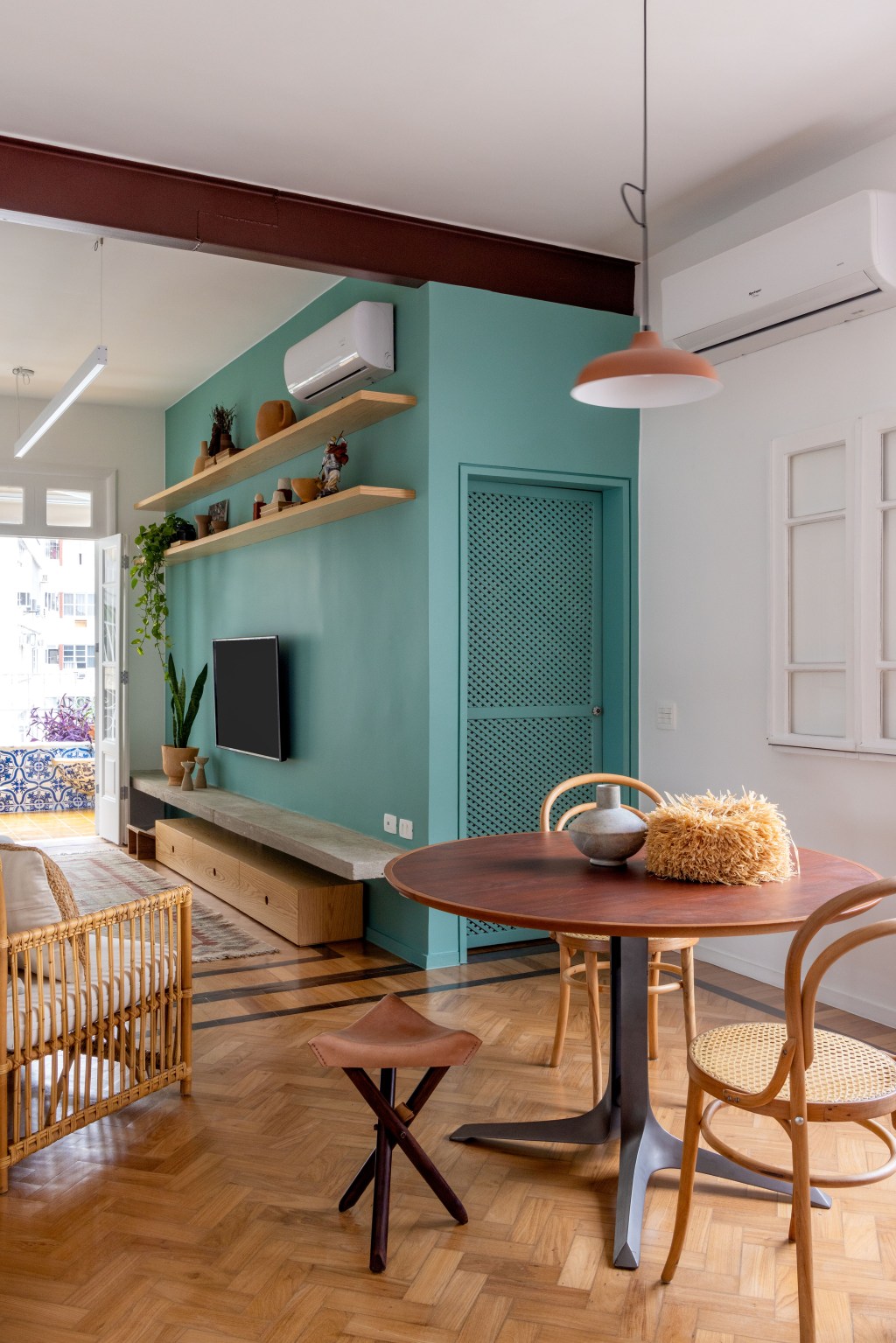 Apê de 90 m² ganha cara de casa com revestimentos charmosos e cores. Projeto Ana Neri. Na foto, sala de jantar com mesa redonda, sala com parede verde.