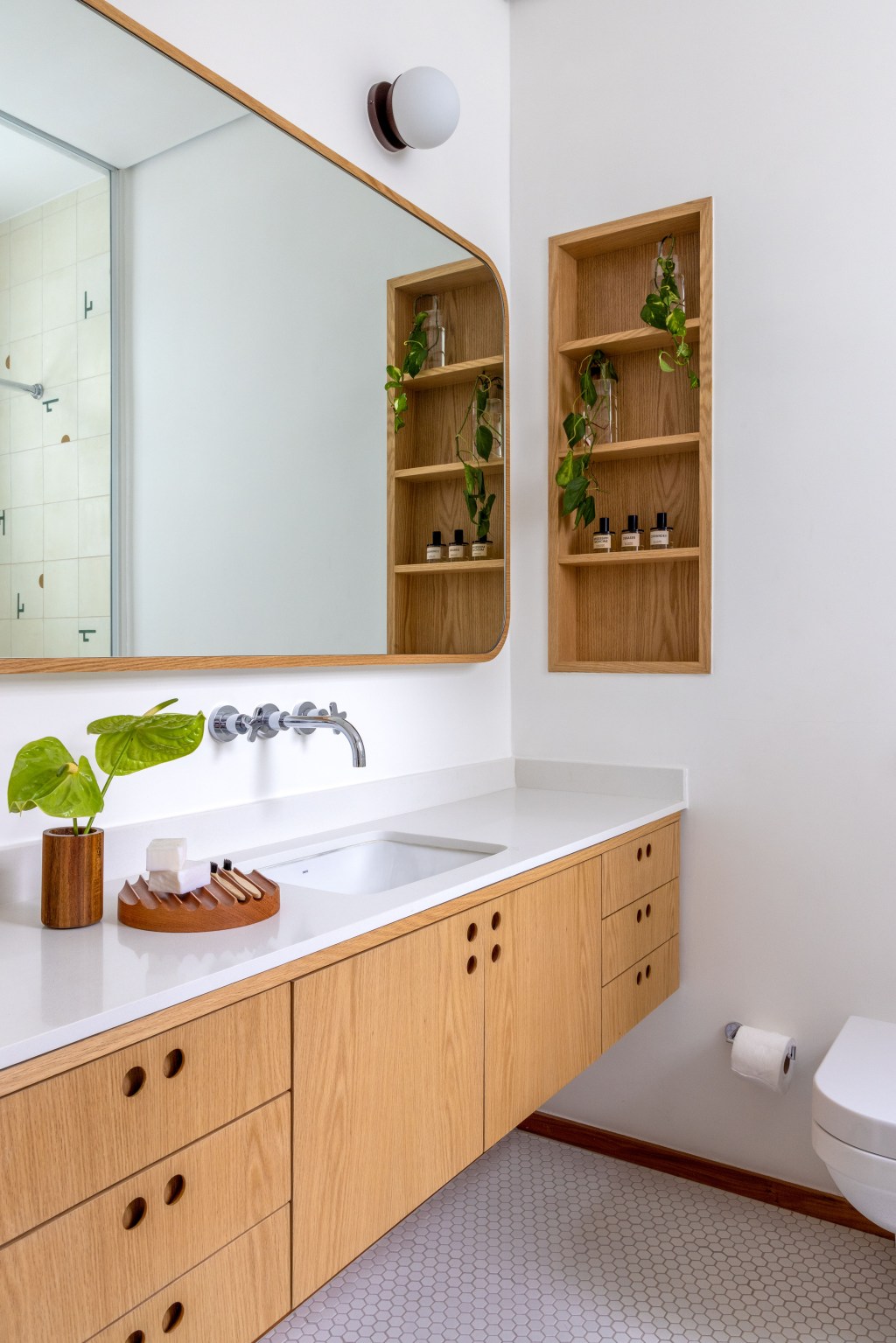 Apê de 90 m² ganha cara de casa com revestimentos charmosos e cores. Projeto Ana Neri. Na foto, banheiro com prateleiras emburtidas e piso hexagonal.