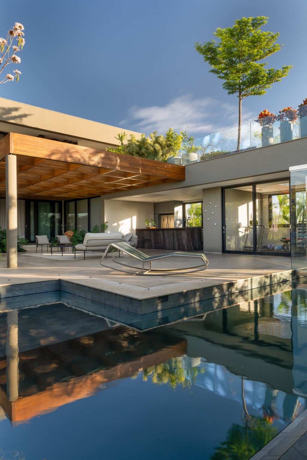 Casa de 717 m² erguida do zero em terreno em declive é repleta de natureza. Projeto de Rogério da Fonseca, do escritório RF Arquitetura. Na foto, varanda co piscina e jardim.