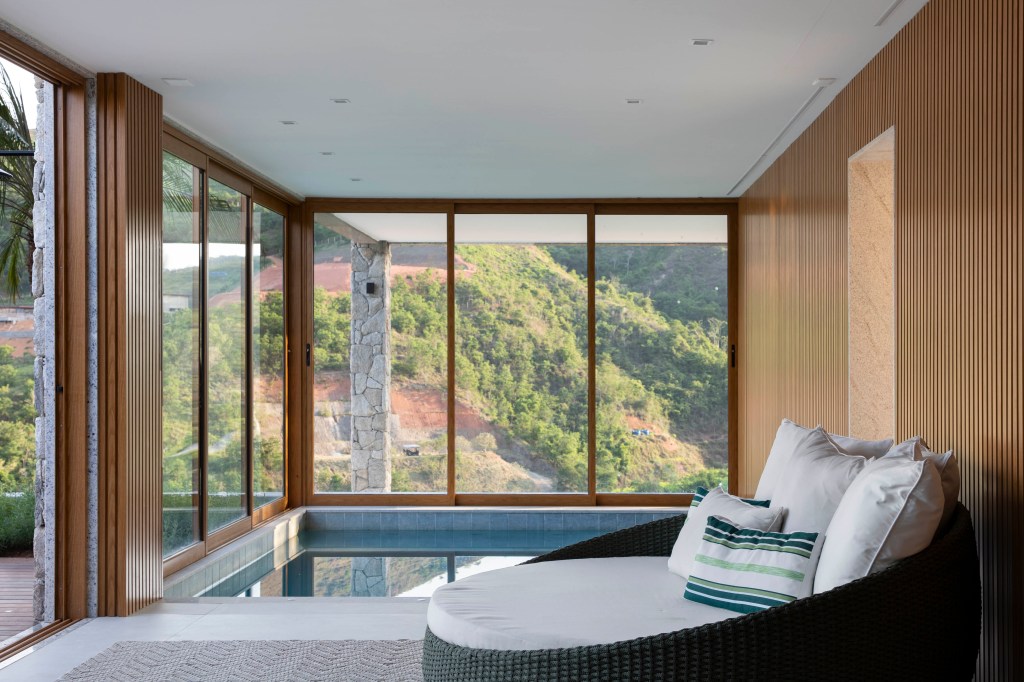 Casa de campo de 800 m² em Petrópolis ganha décor com cara de montanha. Projeto de João Panaggio. Na foto, sauna com poltrona e vista para a serra.