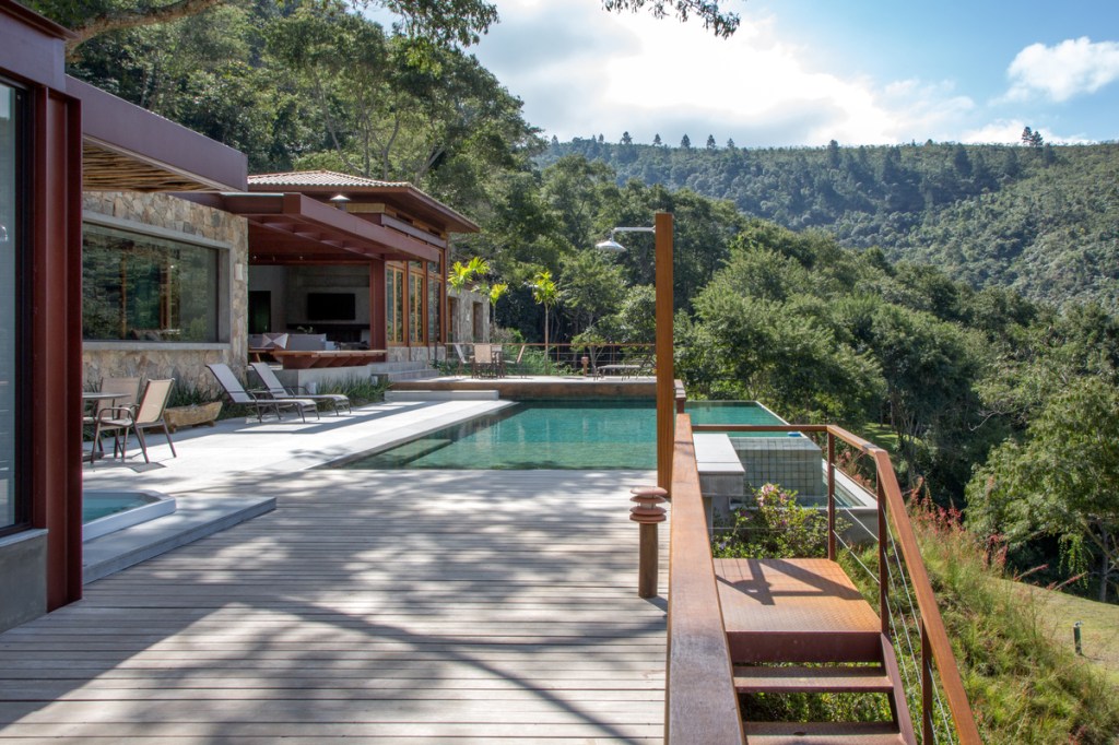 Casa na montanha possui vista espetacular para a Serra das Araras. Projeto de Andrea Chicharo. Na foto, área de lazer com piscina e jardim. Pergolado de bambu.