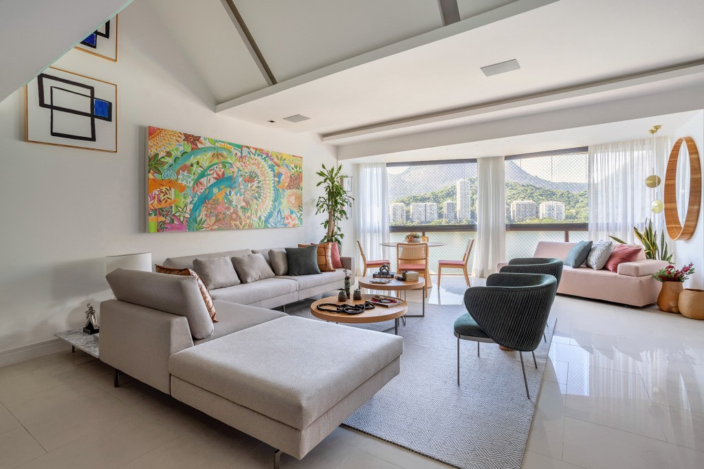 Cores vivas marcam décor deste apartamento de 300 m² com pé-direito duplo. Projeto de Ana Cano. Na foto, sala de estar com vista para a natureza. sofás e quadros.