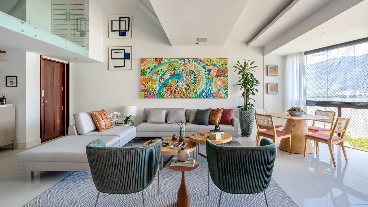 Cores vivas marcam décor deste apartamento de 300 m² com pé-direito duplo. Projeto de Ana Cano. Na foto, sala de estar com vista para a natureza. sofás e quadros.