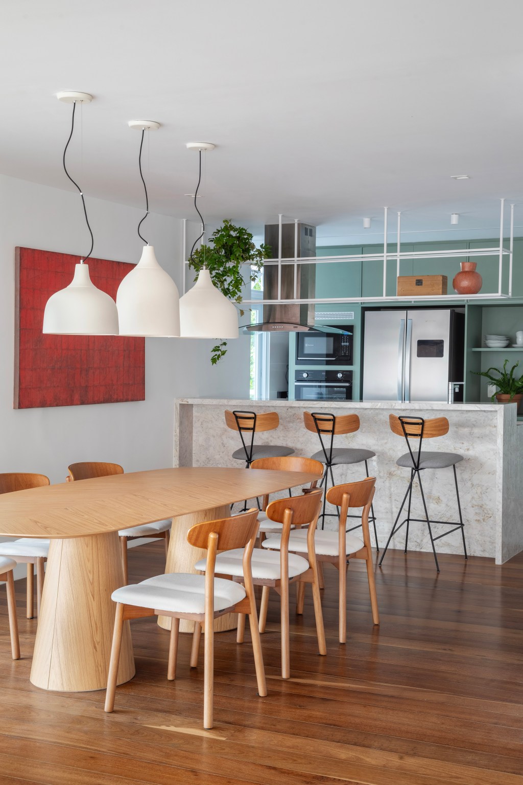Paredes brancas, piso de madeira e armários verdes marcam apê de 280 m². Projeto Beta Arquitetura. Na foto, cozinha americana com armários verdes.