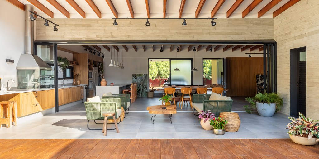 Pensada para veraneio, casa em meio ao verde vira o lar oficial da família. Projeto de Pietro Terlizzi. Na foto, varanda com piscina, jardim e churrasqueira,