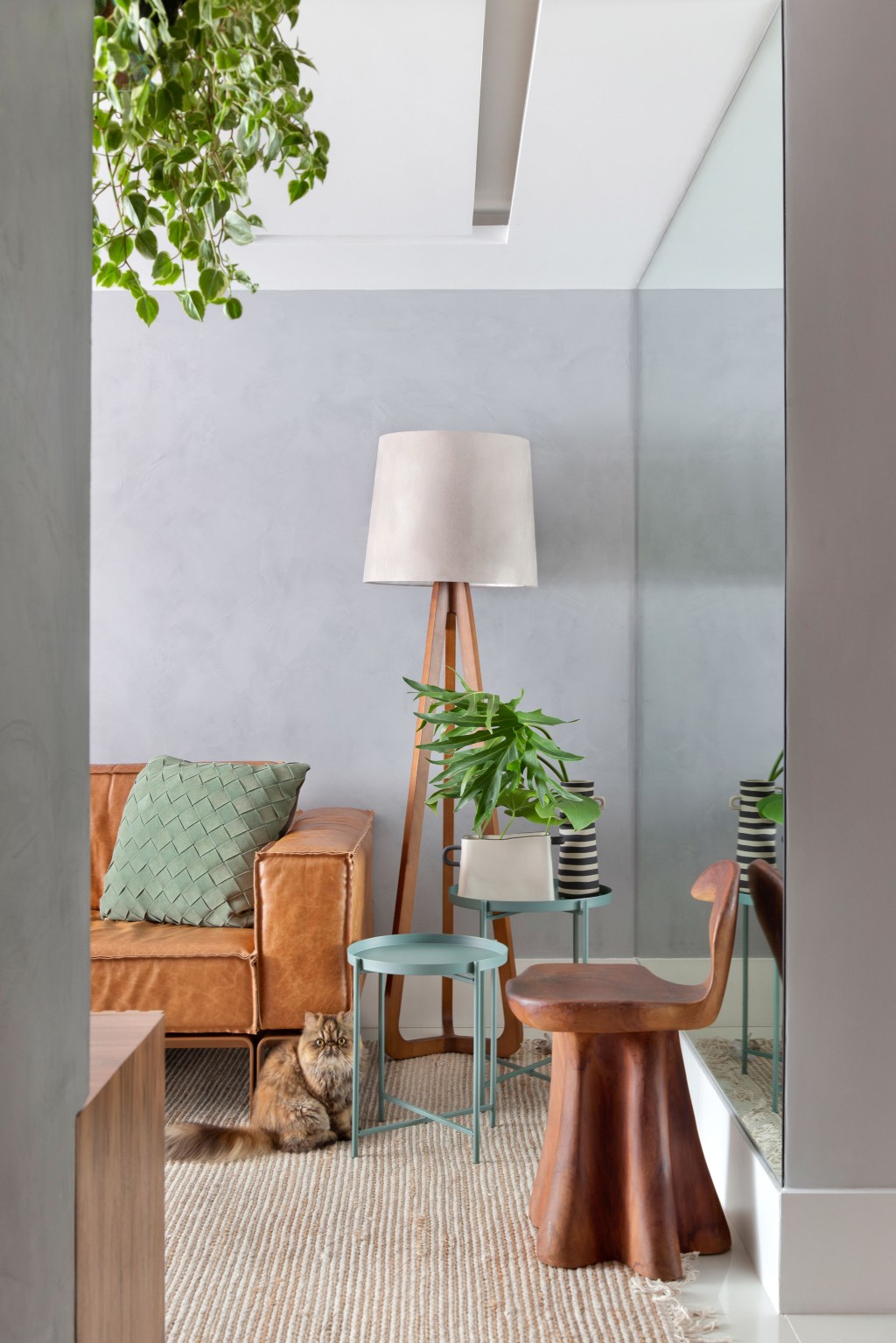 Sem quebra-quebra, apê de 130 m² no Rio ganha décor cozy e minimalista. Projeto Travessa Arquitetura. Na foto, sala com sofá de couro, quadro e tapete.