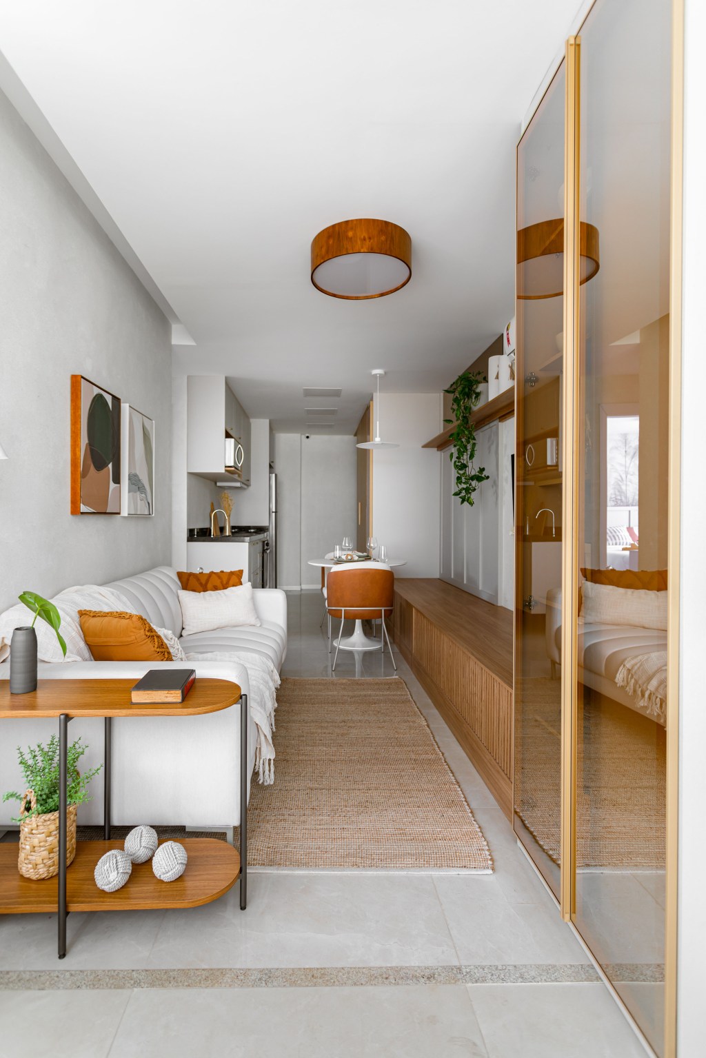 Apê compacto de 56 m² foi projetado para uma família de quatro pessoas. Projeto Nop Arquitetura. Na foto, sala com armário, rack e sofá branco.