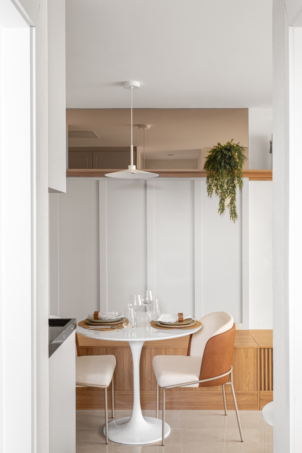 Apê compacto de 56 m² foi projetado para uma família de quatro pessoas. Projeto Nop Arquitetura. Na foto, sala de jantar com mesa redonda e banco.