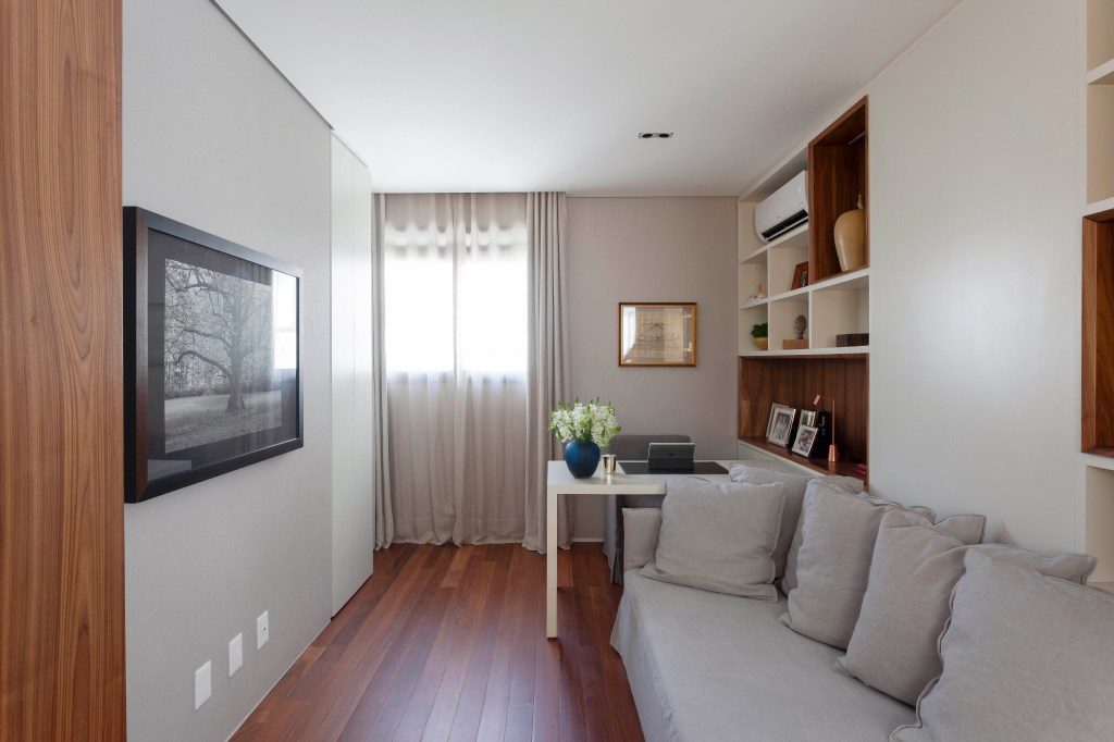 David Bastos assina apartamento clássico de 174 m² em São Paulo. Na foto, home office com quadros e sofá.