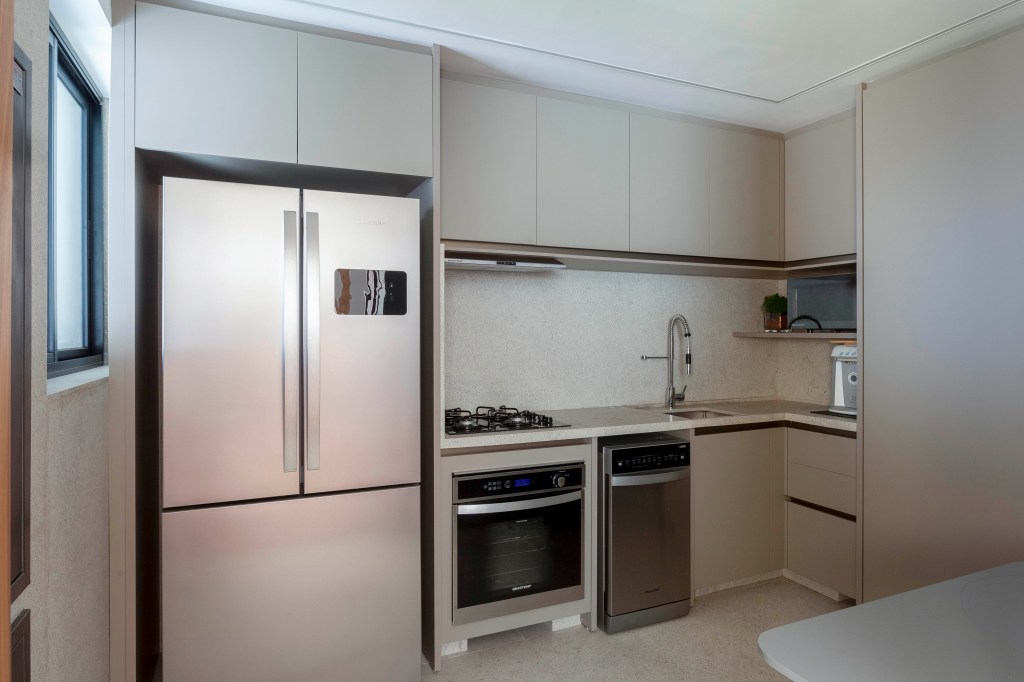 David Bastos assina apartamento clássico de 174 m² em São Paulo. Na foto, cozinha com marcenaria neutra.
