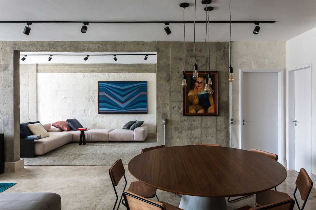 José Navarro assina apartamento de 210 m² no Conjunto Nacional, em SP. Na foto, sala de estar e jantar com mesa redonda e quadros.