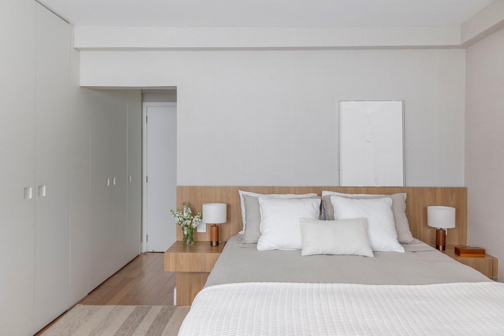 Paola Ribeiro assina apartamento de 196 m² com alma carioca em SP. Projeto de Paola Ribeiro, Na foto, quarto de casal com cabeceira de madeira e quadro.