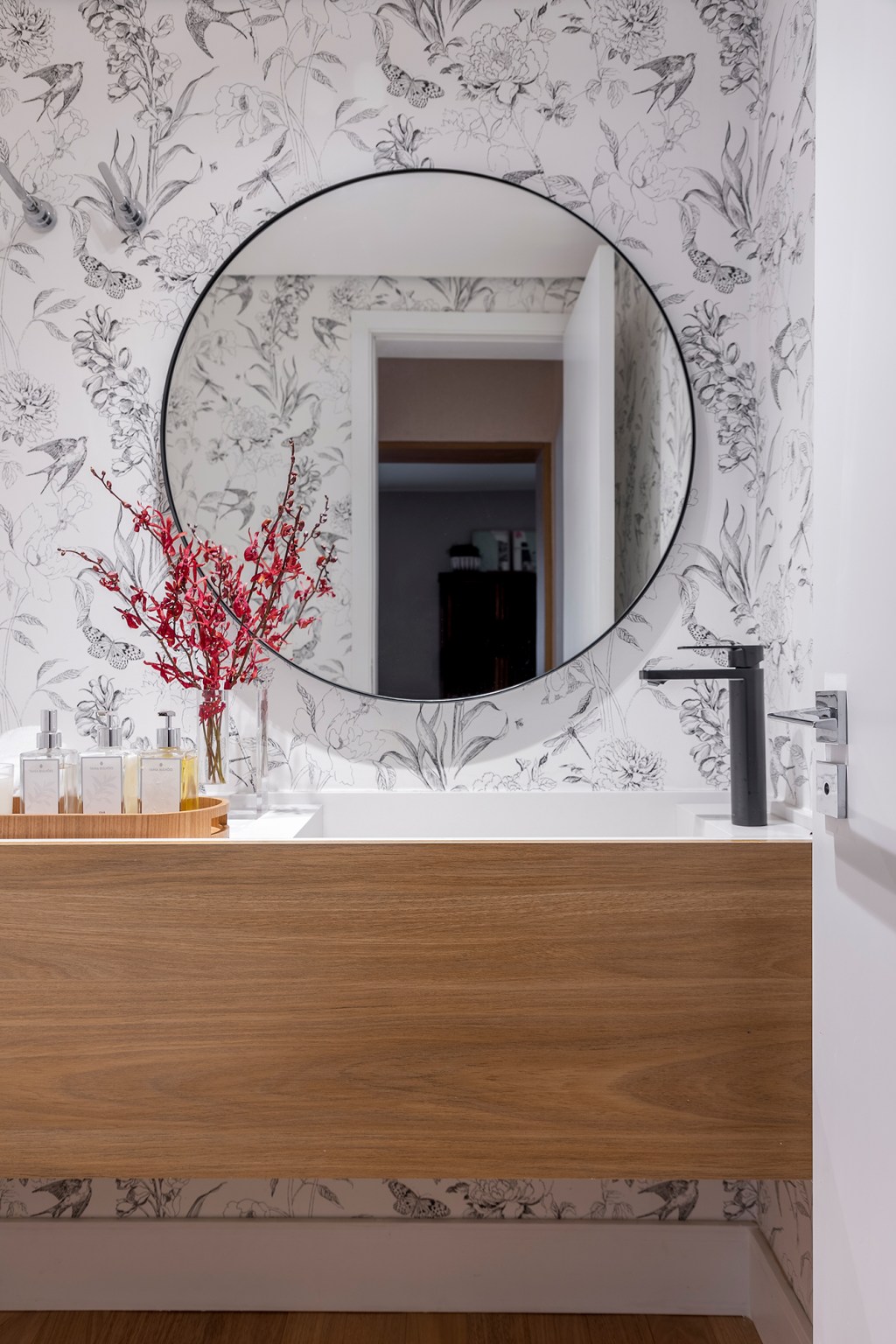 Paola Ribeiro assina apartamento de 196 m² com alma carioca em SP. Projeto de Paola Ribeiro, Na foto, lavabo com papel de parede e espelho circular.