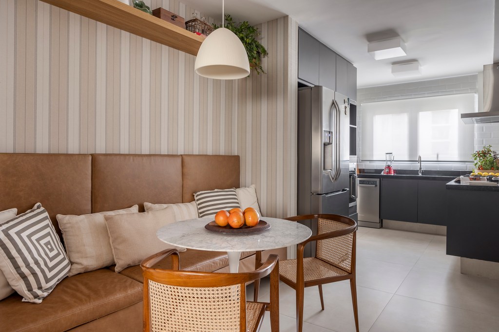 Paola Ribeiro assina apartamento de 196 m² com alma carioca em SP. Projeto de Paola Ribeiro, Na foto, cozinha com copa, canto alemão e marcenaria preta.