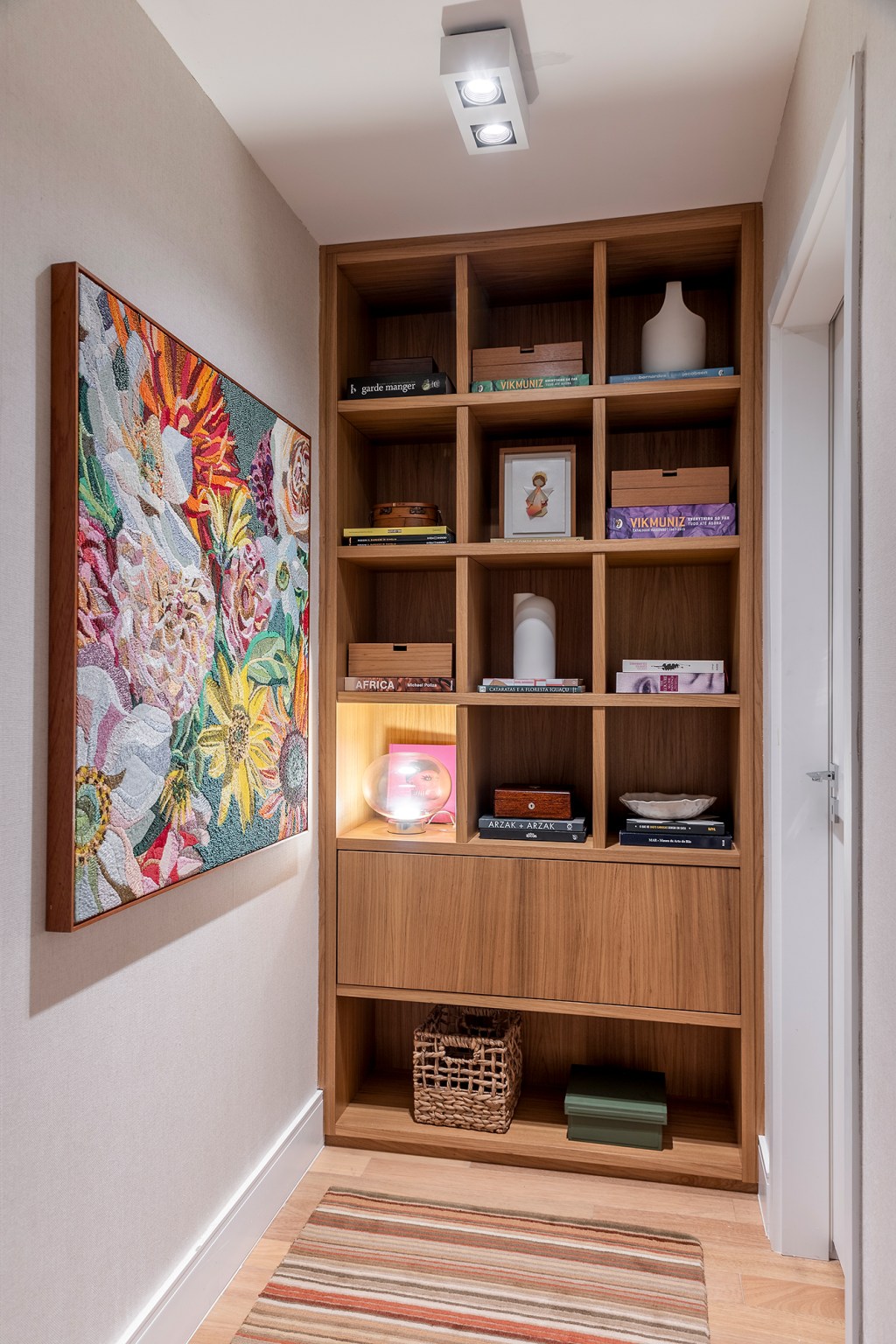 Paola Ribeiro assina apartamento de 196 m² com alma carioca em SP. Projeto de Paola Ribeiro, Na foto, corredor com estante e quadro.
