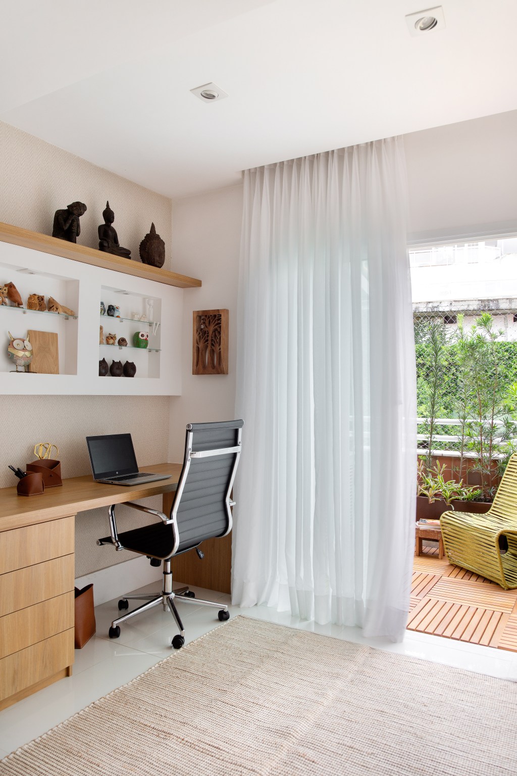 Sem quebra-quebra, apê de 130 m² no Rio ganha décor cozy e minimalista. Projeto Travessa Arquitetura. Na foto, home office com varanda e tapete.