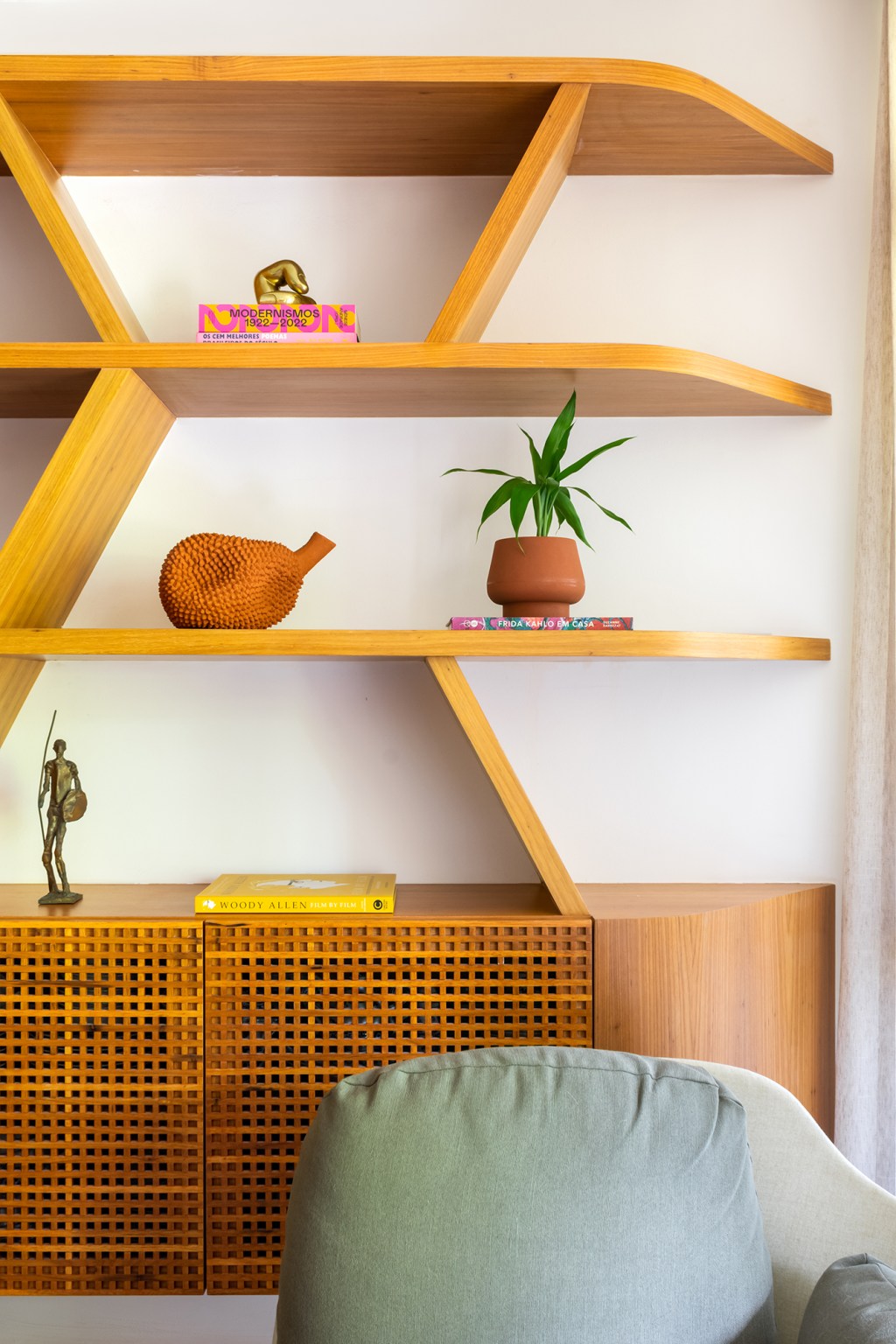 A madeira é a protagonista deste apartamento de 117 m² na Gávea. Projeto de Mariana Monnerat, Na foto, estante assimétrica de madeira.