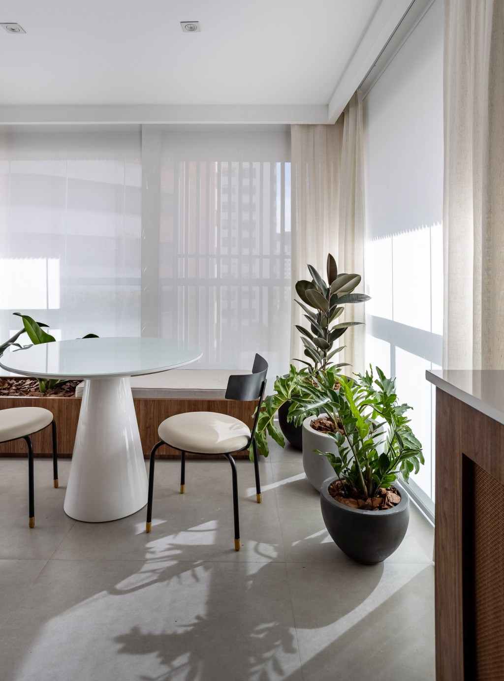 Wabi-sabi norteia a decoração de apartamento de apenas 48 m². Projeto de Carolina Gava. Na foto, sala de jantar com banco e plantas.