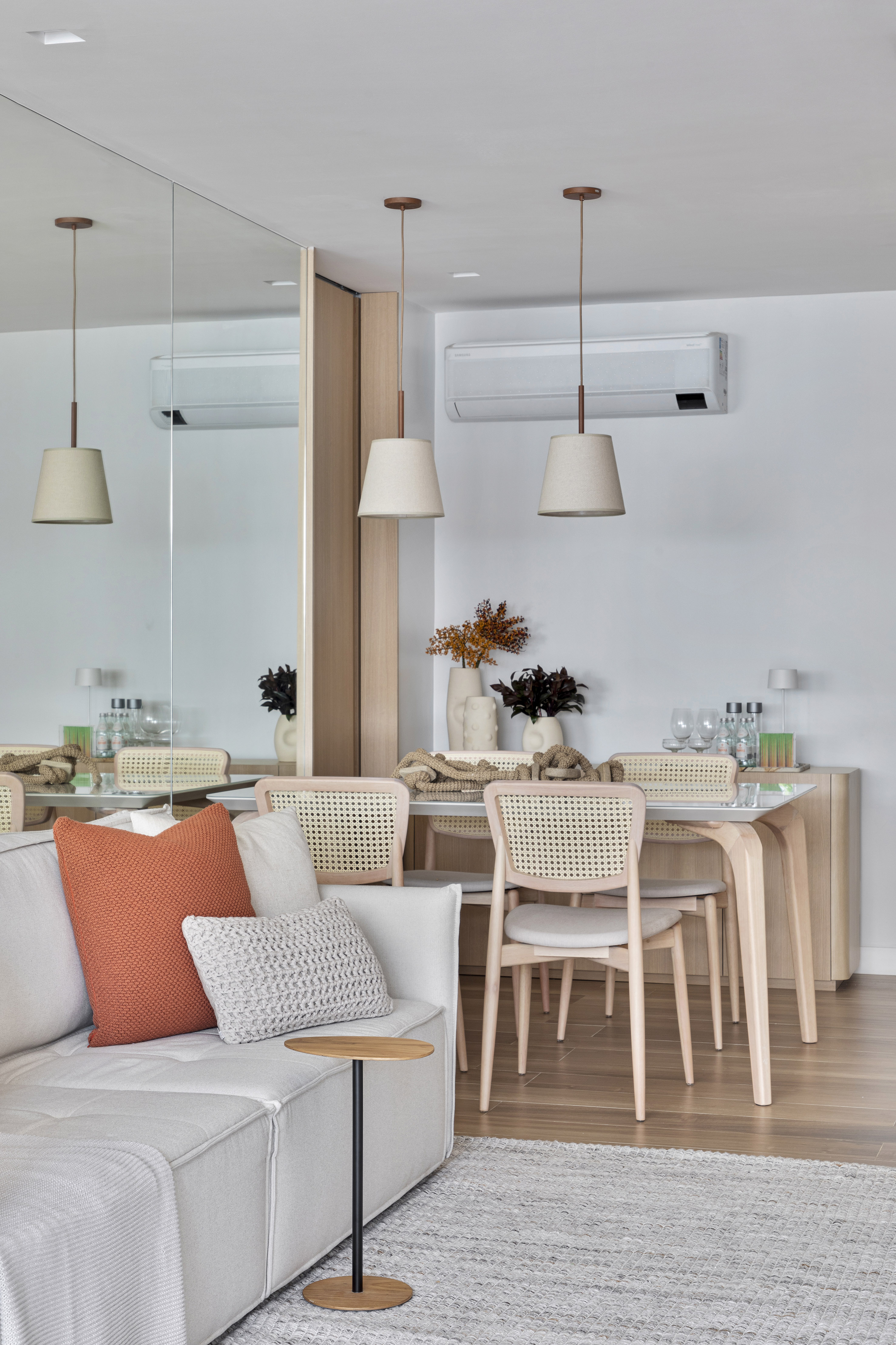 Apartamento de 70 m² parece maior com décor em tons neutros. Projeto de Fabiano Ravaglia. Na foto, sala de jantar com parede espelhada.