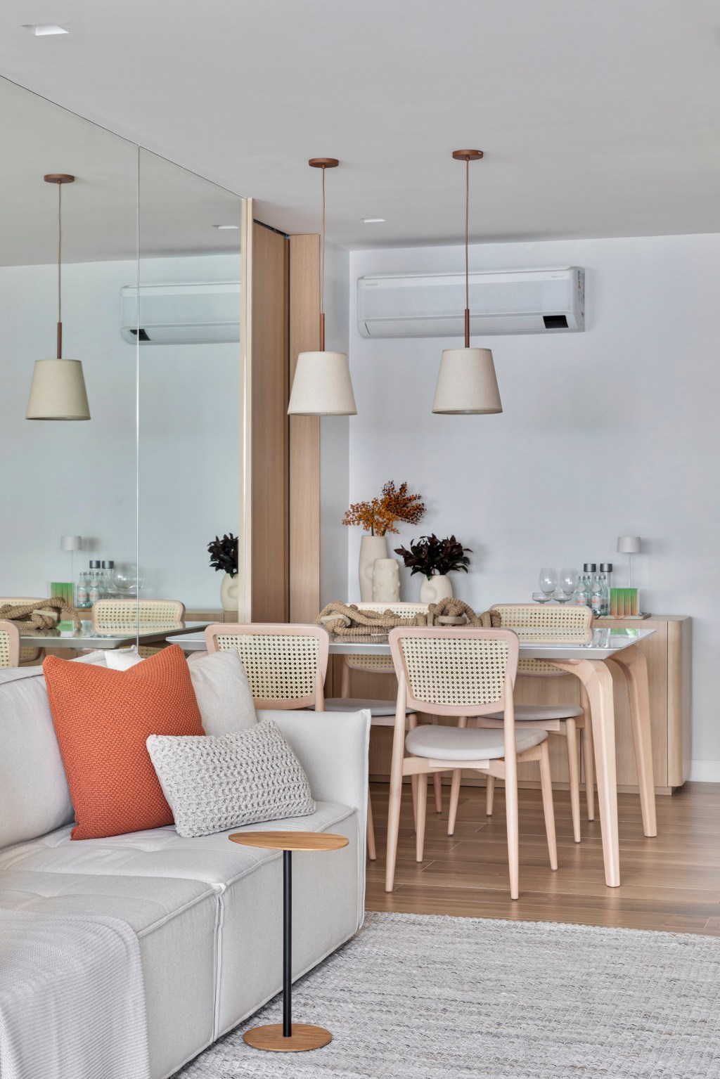 Apartamento de 70 m² parece maior com décor em tons neutros. Projeto de Fabiano Ravaglia. Na foto, sala de jantar com parede espelhada.