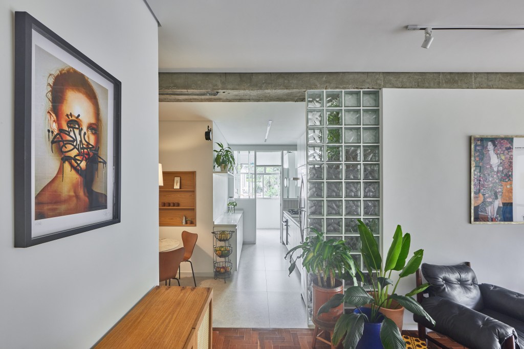 Apartamento de 98 m² ganha décor contemporâneo, mas com toques de brutalismo. Projeto de Hugo Rapizo. Na foto, parede de tijolos de vidro entre sala e cozinha.