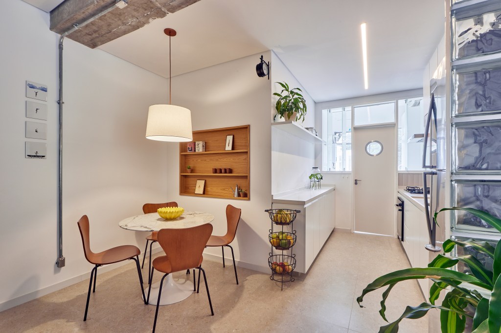 Apartamento de 98 m² ganha décor contemporâneo, mas com toques de brutalismo. Projeto de Hugo Rapizo. Na foto, cozinha com copa e sala de jantar.