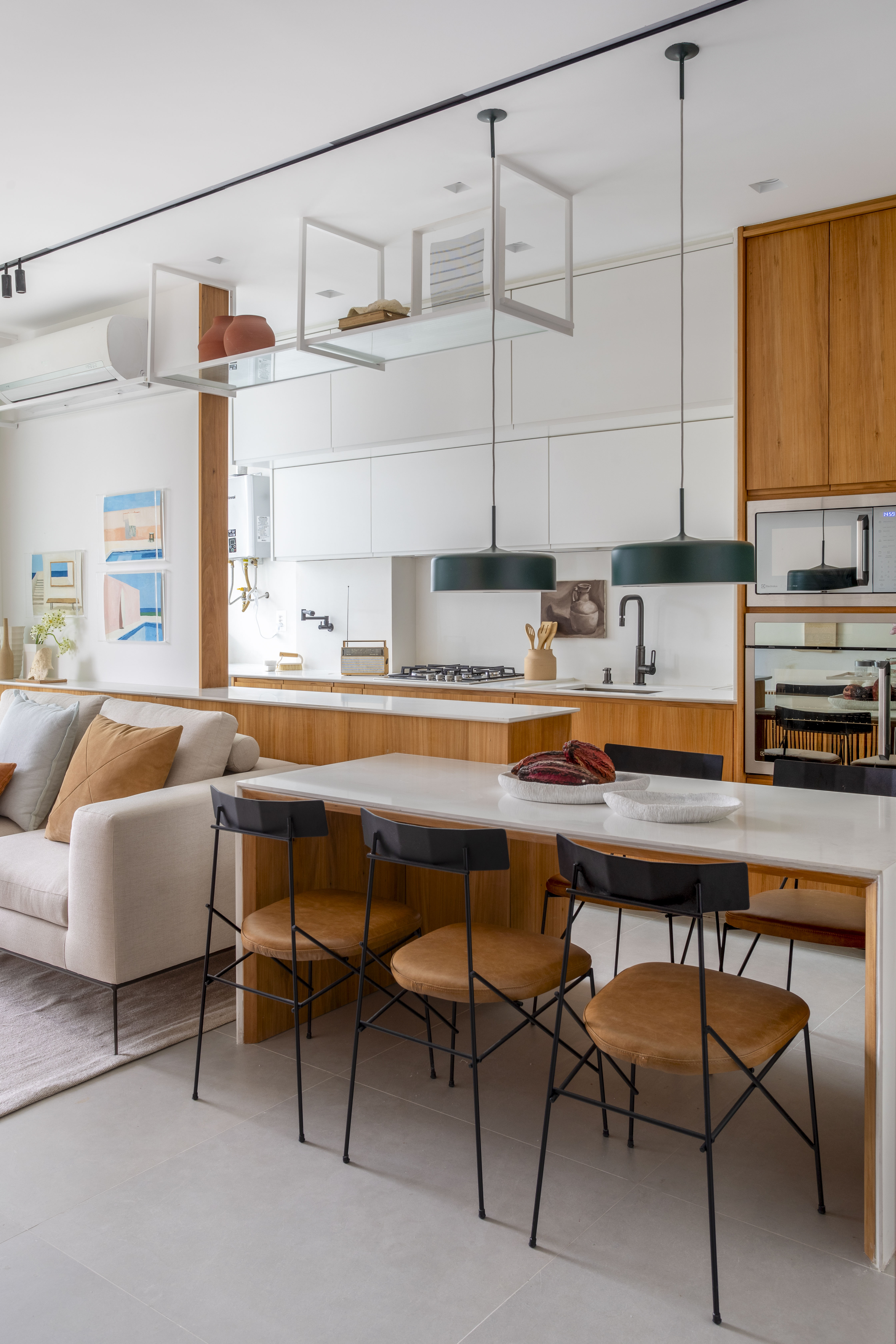 Branco e madeira criam décor cozy em apartamento de 70 m². Projeto de Rafael Ramos. Na foto, cozinha com bancada branca e de madeira.