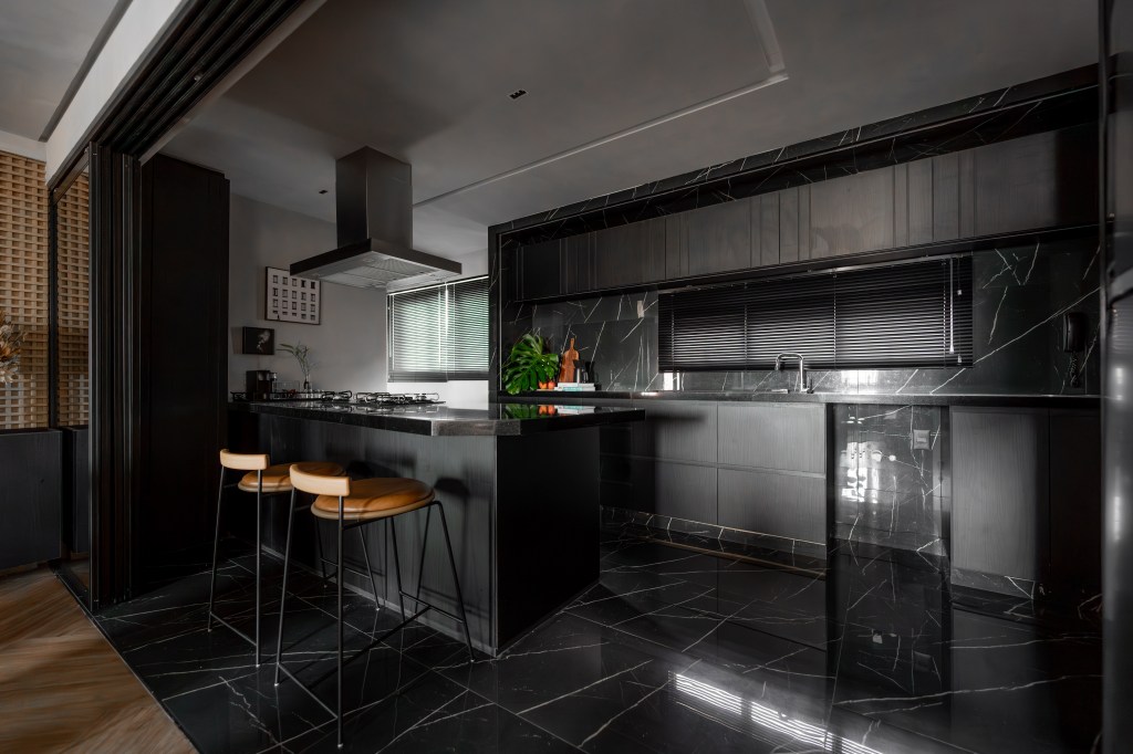 Cores escuras criam sobriedade neste apartamento de 100 m². Projeto de Romário Rodrigues. Na foto, cozinha com móveis e acabamentos pretos.