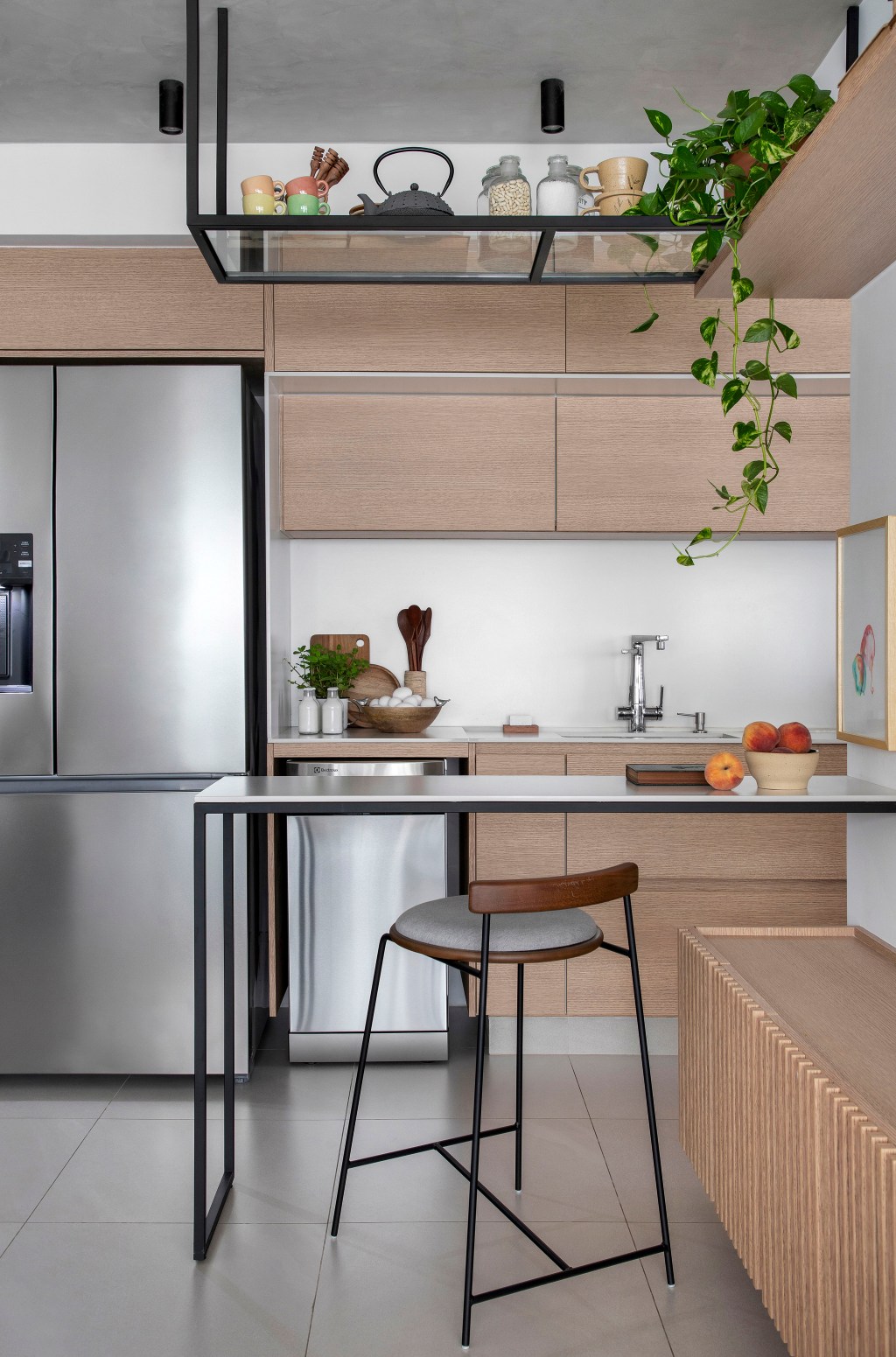 Reforma em apê de 105 m² cria lar aconchegante para mãe e filha. Projeto de Rafael Ramos. Na foto, cozinha integrada com bancada e prateleiras.