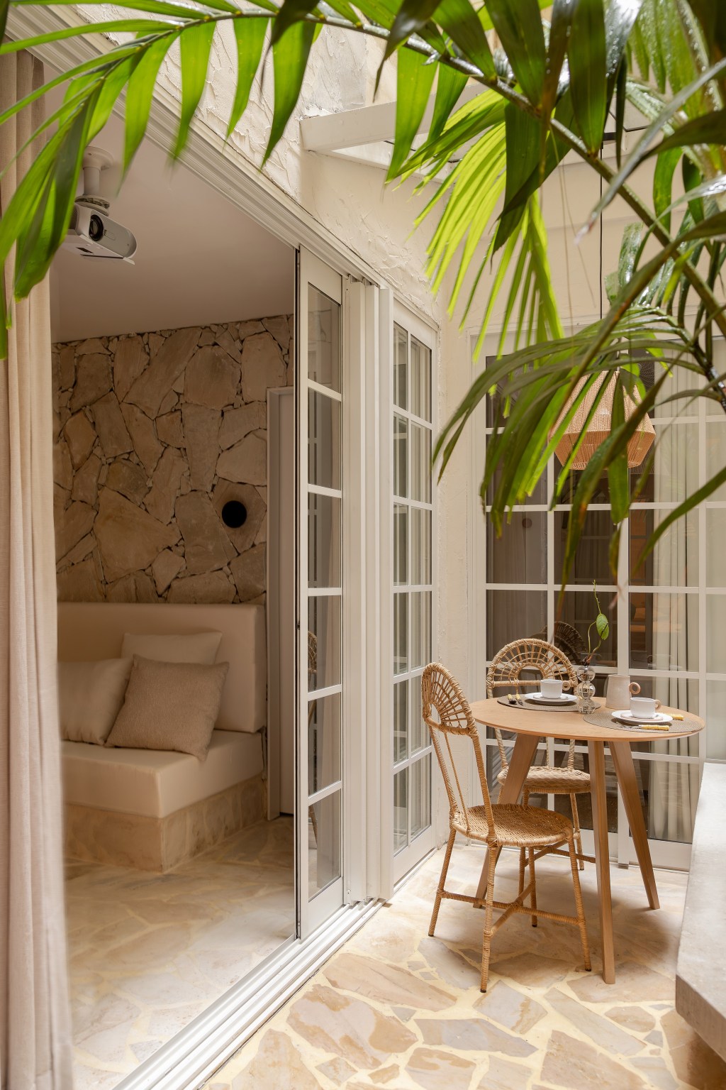 Reforma transforma imóvel de 45 m² em refúgio tropical. Projeto de Tauari Arquitetura. Na foto, pátio com mesa de refeições e banco.