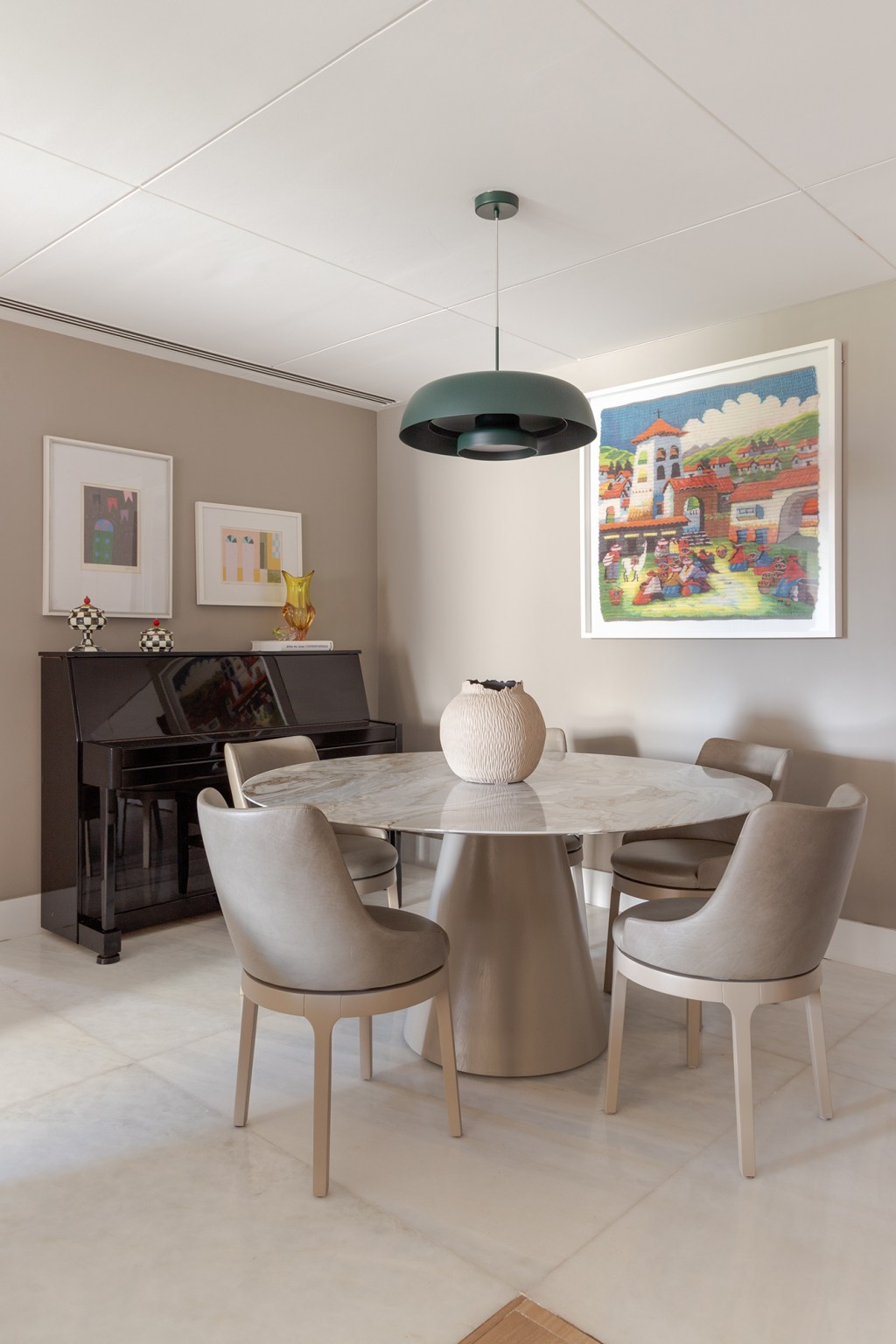 Sem quebra-quebra, apê de 150 m² aposta em tons suaves e cozinha verde. Projeto de Ana Cano. Na foto, sala de jantar com quadros e piano. Mesa redonda.