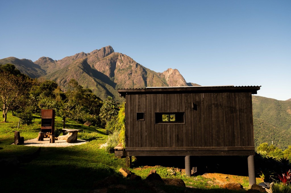 Tiny house sustentável fica a 1500 m de altitude na região serrana de SP. Projeto de Ricardo Delgallo. Na foto, fachada da casa em meio às montanhas.
