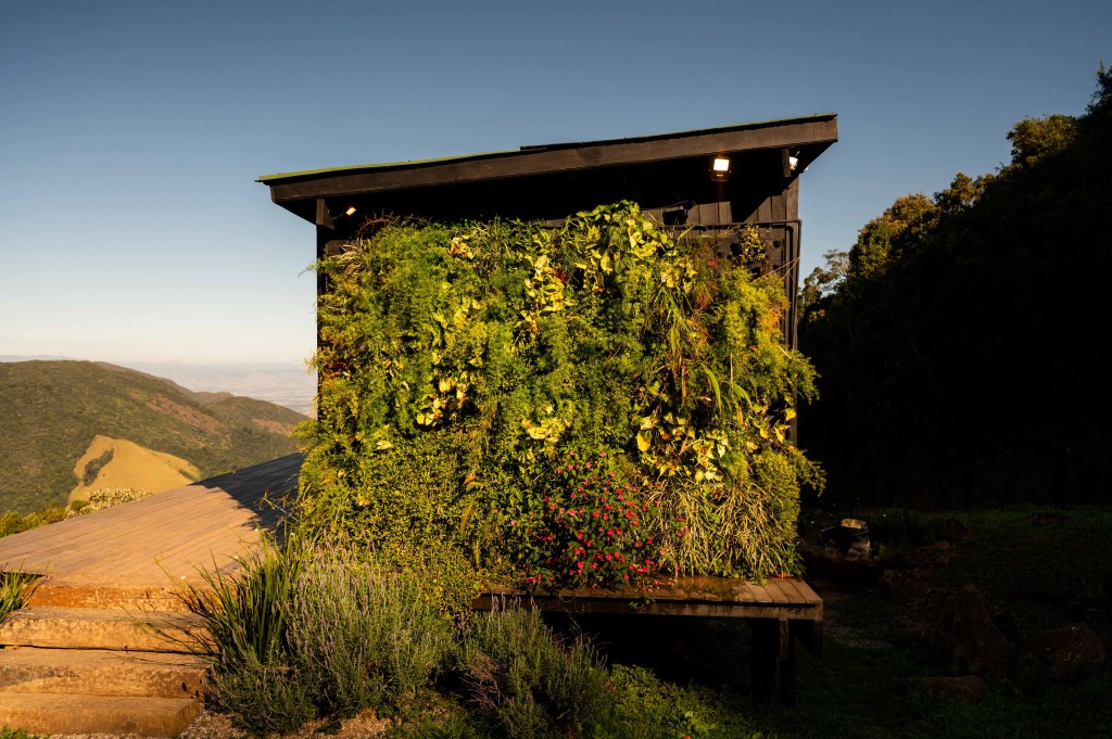 Tiny house sustentável fica a 1500 m de altitude na região serrana de SP. Projeto de Ricardo Delgallo. Na foto, fachada com jardim vertical.
